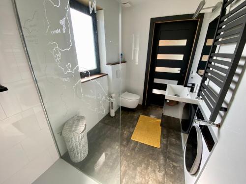 een badkamer met een glazen douche en een toilet bij Mazurski Domek - Wake Up Home Ogonki in Ogonki