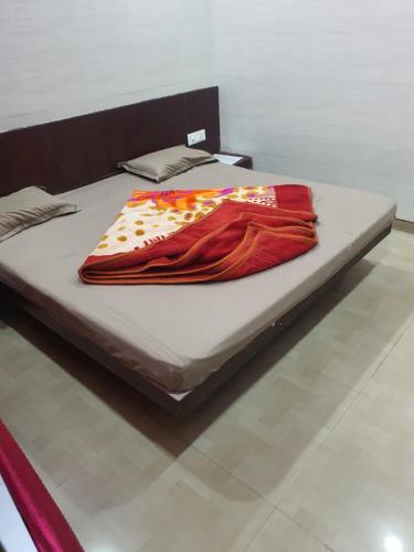 Una cama con una manta roja encima. en HOTEL YUVRAJ, en Haldwāni