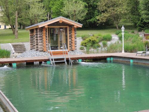 a small cabin on a dock over a pool of water at Wellnesshotel Parkschlössl zu Thyrnau Ihr adults only SPA Resort in Thyrnau