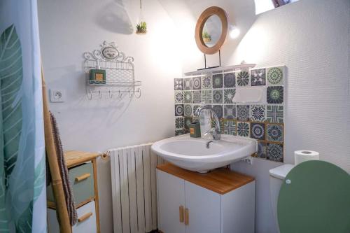 ein kleines Bad mit einem Waschbecken und einem Spiegel in der Unterkunft La Suite Cistude ・Charmant ・Cosy in Le Blanc