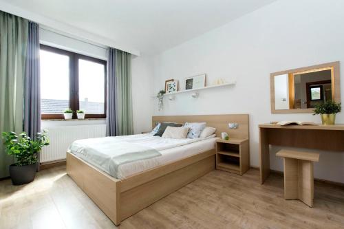 ヤスタルニャにあるmikroKlimat IIのベッドルーム1室(ベッド1台、デスク、窓付)