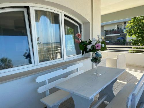 a table and chairs with a vase of flowers on it at Residence Le Terrazze Sul Mare in San Mauro a Mare