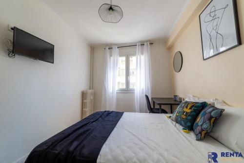 een slaapkamer met een bed en een televisie en een tafel bij Room Riviera 4 Aéroport Wifi Climatisation Partagé in Nice