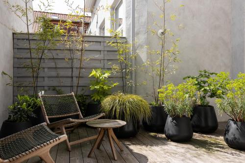 a patio with chairs and potted plants and a table at LuxuryApartmentSoulforCity in Ghent