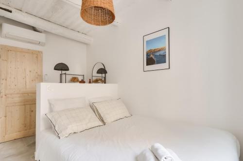 1 dormitorio con paredes blancas y 1 cama con almohadas blancas en Nocnoc - Le Nid, en Marsella