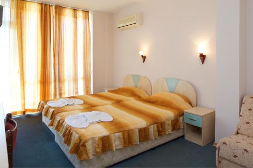 1 dormitorio con 1 cama grande y toallas. en Hotel Arda, en Sunny Beach