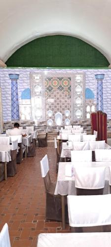 撒馬爾罕的住宿－The Royal Hotel，一间空餐厅,配有白色的桌椅