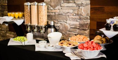a table with plates of food on a table at Podollan Inn & Spa - Grande Prairie in Grande Prairie