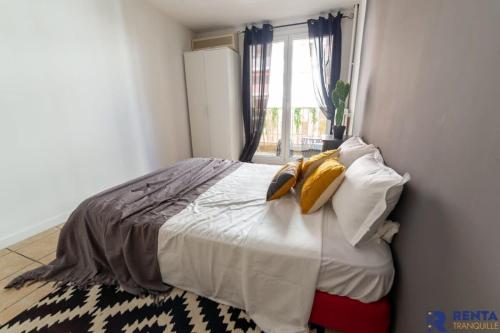 a bedroom with a bed with white sheets and yellow pillows at Chambre 2 René Cassinbalcon Wifi Mini-frigo TV in Nice