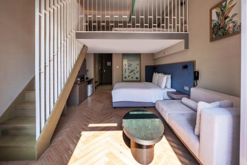 a hotel room with a bed and a couch and a staircase at Holiday Inn Express Beijing Badaling by IHG in Yanqing