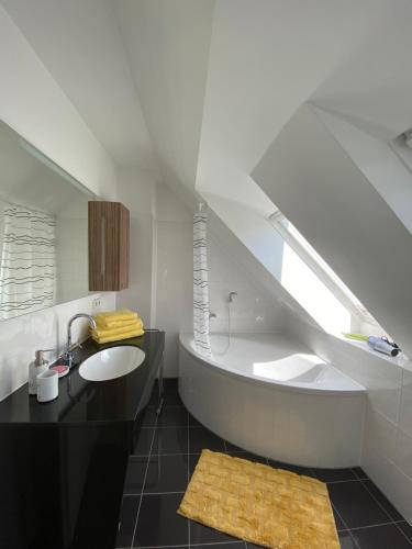 een badkamer met een wastafel en een bad bij Ferienhaus Ferienwohnung Potsdam DieGaLerie am Schlosspark Marquardt 