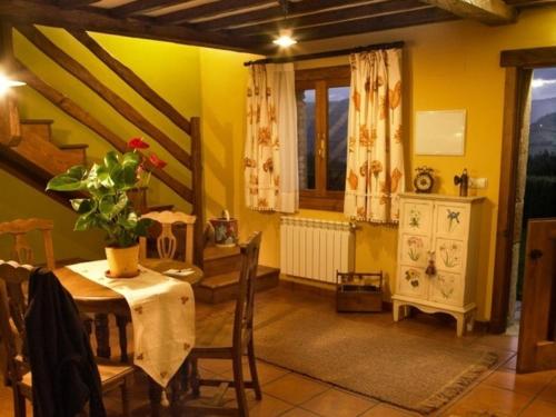 a dining room with a table and a window at Apartamentos Rurales El Mirador de Cazanes in Cazanes