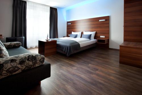 a hotel room with a bed and a couch at Schlotzeria Hotel I Café I Eis in Grenzach-Wyhlen