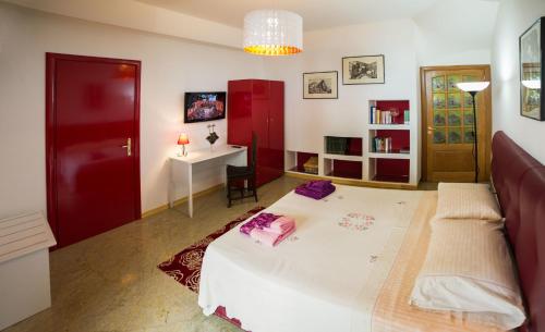 a bedroom with a white bed and a red door at Colapesce in Santa Teresa di Riva