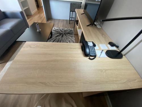 a wooden table with a phone on top of it at Roygent Parks Hai Phong in Hai Phong