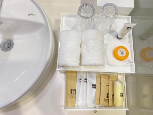 a group of towels and a sink in a bathroom at Roygent Parks Hai Phong in Hai Phong