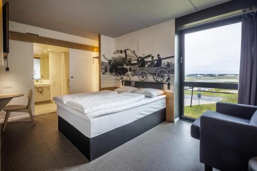 a bedroom with a large bed and a large window at Airport Hotel, Billund in Billund