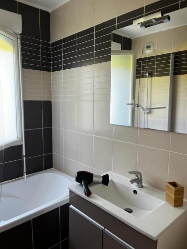 une salle de bain avec un lavabo, une baignoire et un miroir dans l'établissement E41 La Ferme de Deauville 1 ch. SOZEN C., à Saint-Arnoult