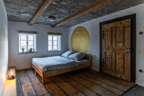 een slaapkamer met een bed en een houten deur bij Cimra bude! in Horní Prysk