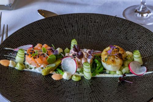 a plate of food with seafood and vegetables on a table at Fletcher Hotel Jan van Scorel in Schoorl