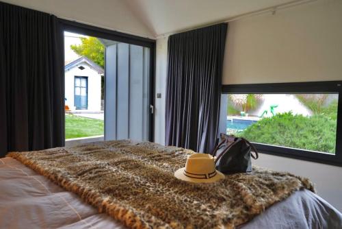 a hat sitting on top of a bed with a window at Magnifique Villa La Rochelle Centre Ville in La Rochelle