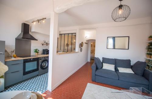 un salon avec un canapé bleu et une cuisine dans l'établissement 4 couchages aux pieds des musées - WiFi, à Grasse