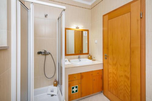 a bathroom with a shower and a sink and a toilet at Falésia Beach Villa by The Portuguese Butler in Olhos de Água