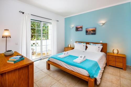 1 dormitorio con cama, escritorio y ventana en Falésia Beach Villa by The Portuguese Butler en Olhos de Água