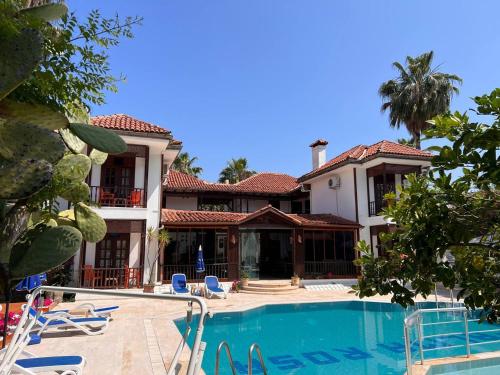una casa grande con piscina frente a ella en Palma Rosa Hotel, en Kemer