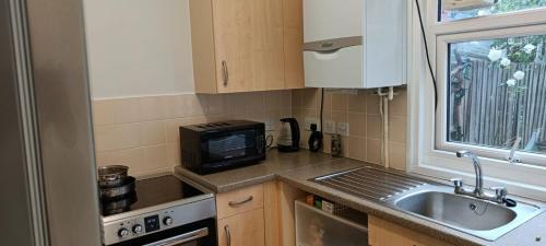 a small kitchen with a sink and a microwave at One Bedroom House in a Quiet Neighbourhood in London