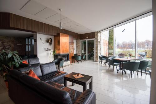 a living room with couches and a table and chairs at Penzion Troja in Lipany