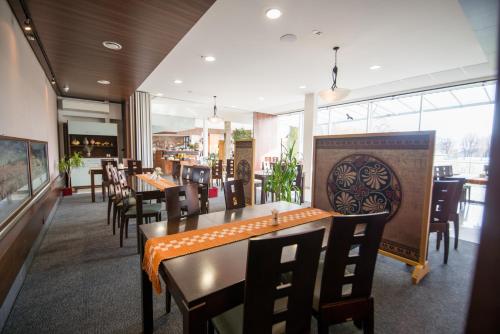 a dining room with tables and chairs and a restaurant at Penzion Troja in Lipany