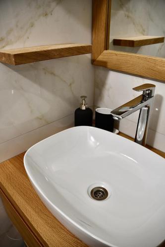 a white sink in a bathroom with a mirror at Olimian Oasis Village Lipa 107 in Podčetrtek