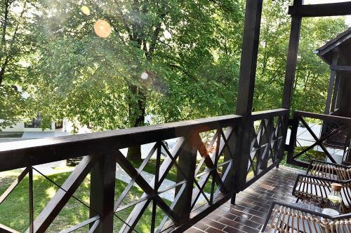 a porch with two chairs and a fence and trees at Olimian Oasis Village Lipa 107 in Podčetrtek