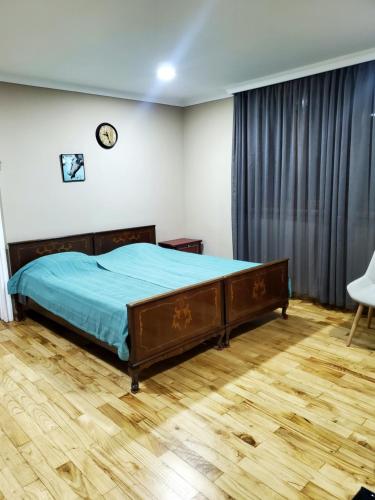 um quarto com uma cama e piso em madeira em Guest house Agmashenebeli 229 em Kobuleti