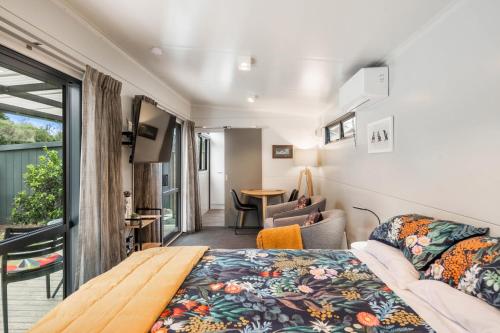 1 dormitorio con 1 cama y sala de estar en Birdsong - Turangi Holiday Unit en Turangi