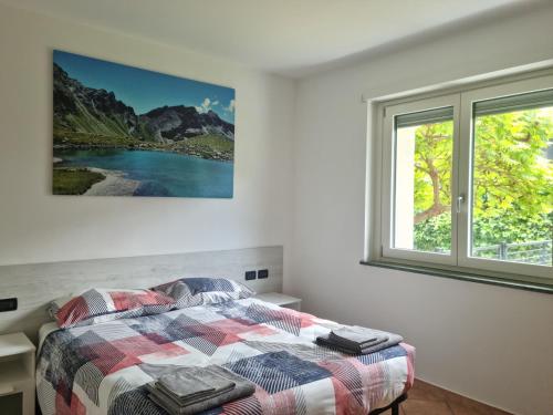 um quarto com uma cama e uma janela em Suite vacanze Chabloz nel cuore della Valle d'Aosta em Nus