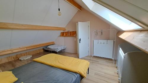 een zolderkamer met een bed en een raam bij Woning in Born in Born