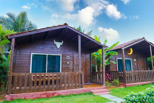 a small wooden cabin with a fence in a yard at Casa De Silver in Baga