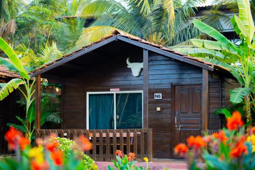 a small wooden house with a cat on the roof at Casa De Silver in Baga