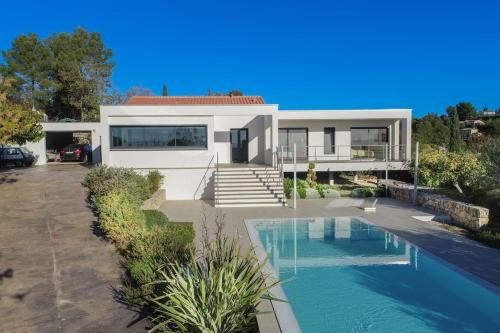 une maison avec une piscine en face de celle-ci dans l'établissement L'élixir - Architect villa & Heart of Provence, à Flayosc