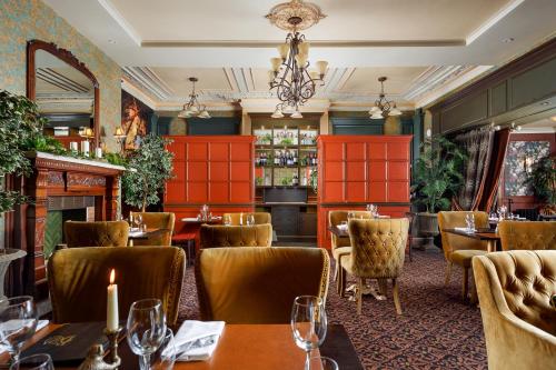 um restaurante com mesas e cadeiras e uma lareira em The Bath Hotel em Lynmouth