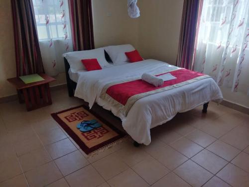 ein Schlafzimmer mit einem großen Bett mit roten Kissen in der Unterkunft La petals hideaway house Machakos in Machakos