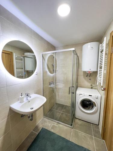 a bathroom with a sink and a washing machine at A1 Miladinovic in Kraljevo