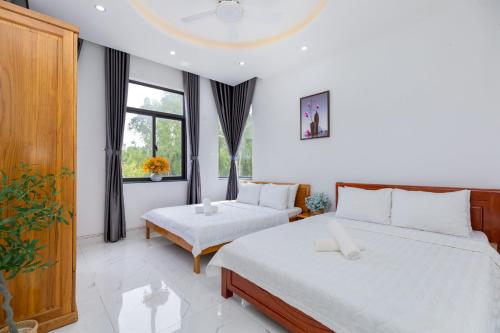 une chambre avec deux lits et une grande fenêtre dans l'établissement Đặng Diễm My Villages C2.49, à Vung Tau