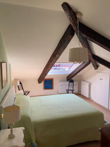 1 dormitorio con 1 cama verde y 2 sillas en Casa Tella en Venecia