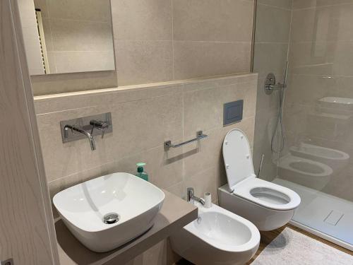 ein Badezimmer mit einem weißen WC und einem Waschbecken in der Unterkunft [Riviera Apartments] Near the beach + Parking in Rosolina Mare