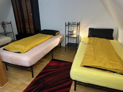 two beds with yellow sheets in a room at Ferienzimmer Healing und Montuerwohnung in Weißenfels