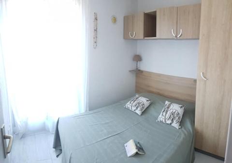 une chambre avec un lit avec deux oreillers dessus dans l'établissement T2 Qaurtier Couchant, Vue parc, au calme, à 5 min de la plage, à La Grande Motte
