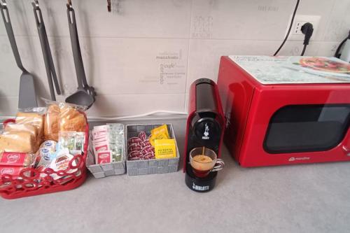 a red microwave next to a toaster and some food at Casa Stadio - Parco Dora in Turin
